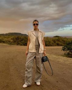 Elevate your safari experience with these casual and classy travel outfit essentials! Perfect for women traveling to South Africa, Tanzania, and Namibia, our guide features elegant and comfortable outfit ideas that are ideal for the wild, just like this chic safari outfit with grey cargo pants. Safari Outfit Women, Stylish Cargo Pants, Silk Shirt Outfit, Cass Dimicco, Elevated Outfits, Safari Outfit, Safari Outfits, Women Traveling, Cargo Pants Outfits