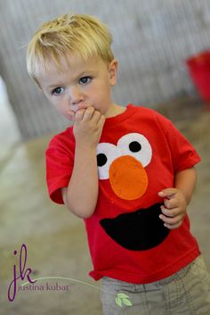 a young boy wearing a red shirt with an angry bird on it's chest