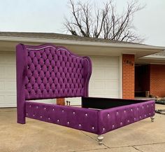 a purple bed sitting in the middle of a driveway