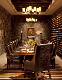 a dining room with a table and chairs in front of a painting on the wall