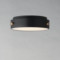 a black ceiling light hanging from the ceiling in a room with grey walls and flooring