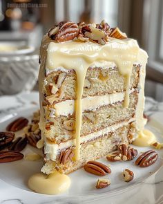 a slice of cake on a plate with pecans and icing drizzled over it