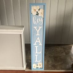 a wooden sign that says hey y'all with flowers painted on the front and back