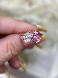 a woman's hand holding two different colored diamonds