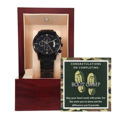 a black watch in a wooden box with a sign on it that says congratulationss on completing boot camp