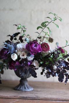 a vase filled with lots of purple and white flowers