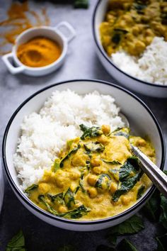 two bowls filled with white rice and spinach curry