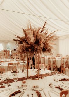 the tables are set with white linens and tall centerpieces