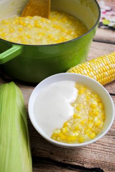 corn and cream in a green pot next to an ear of corn