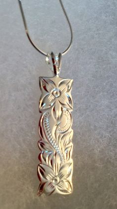 "Solid .925 Sterling Silver Hawaiian Heirloom Plumeria Pua Melia Scroll Necklace. The size is 38MMx10MM, about 1.5\" long. FREE Sterling Silver Italian Snake Chain w/lobster claw clasp included in your choice of length. This labor-intensive design is always a bestseller in our Hawaii stores. --This design features a Plumeria Flower Scroll. This iconic Flowers bright colors, beautiful shape and amazing scent greet you on a daily basis in the Islands. Often used in Lei making, it is worn and excha Silver Carved Rectangular Jewelry, Carved Silver Rectangular Jewelry, Silver Rectangular Carved Jewelry, Carved Rectangular Silver Jewelry, Lei Making, Hawaiian Necklace, Tropical Jewelry, Larimar Necklace, Heritage Jewellery