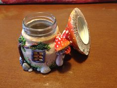 a glass jar sitting on top of a wooden table next to a mushroom shaped object