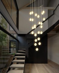 a modern chandelier hanging from the ceiling in a room with wood flooring