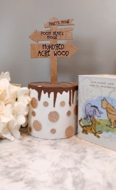 a winnie the pooh themed birthday cake with a wooden sign that says happy birthday