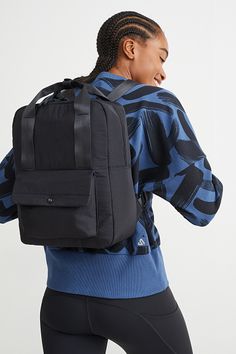 a woman wearing a black backpack and blue shirt