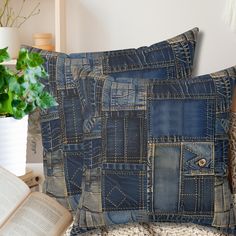 two pillows made out of old jeans sit on a chair next to an open book