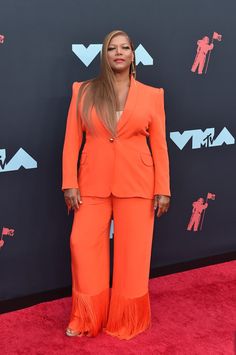 the singer is wearing an orange suit and matching heels at the vmas awards ceremony