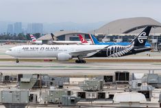 an air new zealand plane on the tarmac at an airport in front of other planes