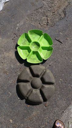 a green flower sitting on top of a sidewalk next to a cement planter with the words create your own garden share