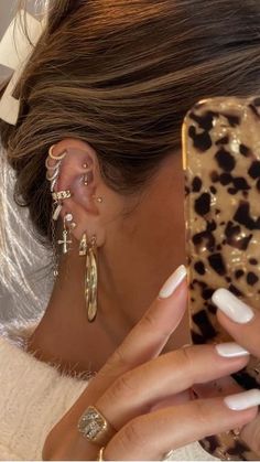 a woman is taking a selfie with her cell phone while wearing ear cuffs