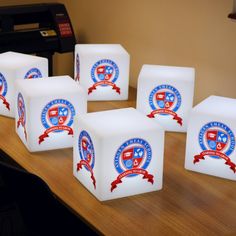 four white cubes with red and blue designs on them sitting on a table next to a keyboard