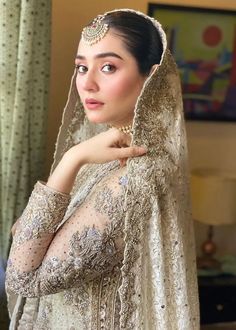 a woman in a bridal gown poses for the camera