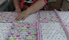 an older woman is making quilts with her hands on top of the quilting