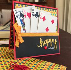 a birthday card holder with playing cards in it and a pair of scissors on the table