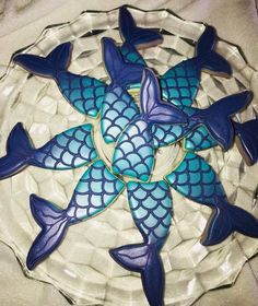 there are some cookies shaped like fish in the shape of a star on top of a glass plate