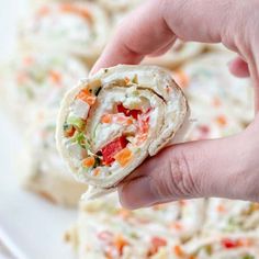 a hand holding a tortilla filled with veggies