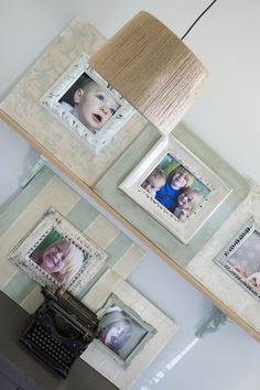 two framed pictures on the wall above an old typewriter with a lamp hanging over it