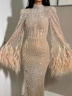 A model wearing the nude feather evening gown, showcasing its elegant silhouette and flowing train. Golden Atelier 8 Feather Evening Gown, Nude Evening Dresses, Gown With Long Sleeves, Arabic Wedding, Arab Wedding, Long Sleeve Dress Formal, Flare Long Sleeve, Long Sleeve Evening Dresses, Full Dress