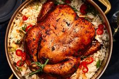 a roasted chicken on top of rice in a pan