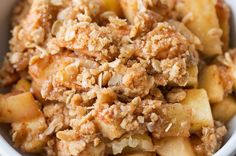 a close up of a bowl of food with fruit and nuts on top, ready to be eaten