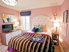 a bedroom decorated in pink, purple and white with a bed topped with a tray of food