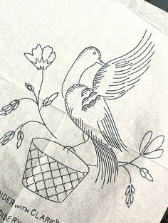 a piece of paper with an image of a bird on it and flowers in the background