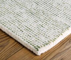 a close up of a rug on a wooden floor with wood floors and white carpet