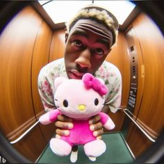 a man holding a pink hello kitty stuffed animal