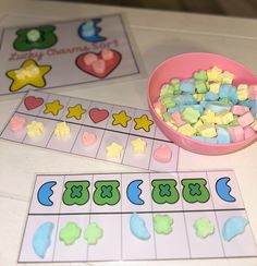 a bowl of gummy bears sitting on top of a table next to two matching cards