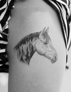 a horse tattoo on the side of a woman's thigh