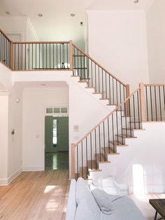 a living room filled with furniture and a stair case in front of a door on the wall