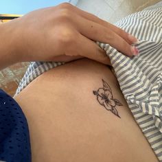 a close up of a person's stomach with a flower tattoo on the side