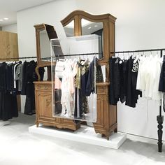 a clothing store with clothes on racks and mannequins