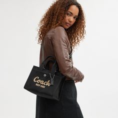 Carry as much (or as little) as you like with our lightweight Cargo tote. Detailed with our cursive Coach script embroidery and iconic turnlock closure this compact 26 has an open interior with room for an iPad two outside pockets for easy organization and a removable webbing strap for shoulder or crossbody wear. Crafted to last this versatile carryall is made with cotton sourced from farms that use regenerative agricultural practices* and inspired by our commitment to reducing our impact on the Luxury Calvin Klein Shoulder Bag, Coach Bag Blck, Coach Bags Handbags 2022, Coach Handbags Coach, Luxury Calvin Klein Shoulder Bag For Everyday, Everyday Calvin Klein Shoulder Bag, Coach Hamdbags, Luxury Everyday Calvin Klein Shoulder Bag, Coach Bags Handbags Coach