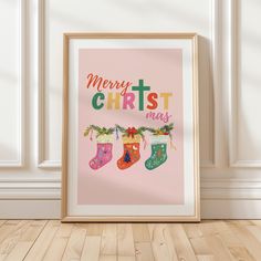 a pink poster with christmas stockings hanging from it's sides on a wooden floor