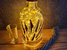 a lighted bottle next to a shot glass on a wooden table with a chain around it