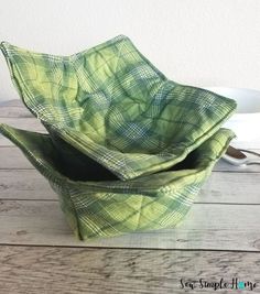 two green bowls sitting on top of a wooden table