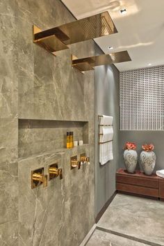 a modern bathroom with gold fixtures and marble walls