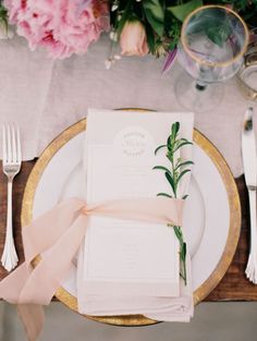 an image of a table setting with place settings and flowers on the plate, along with napkins