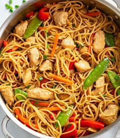 a pan filled with noodles, chicken and veggies