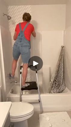 a person standing on a ladder in a bathroom